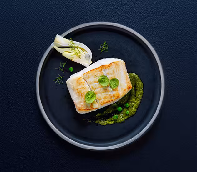 Pan fried Norwegian halibut with baked fennel, fresh peas and haricot verts sauté and chimichurri