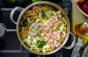 Creamy pasta with peas, broccoli and prawns