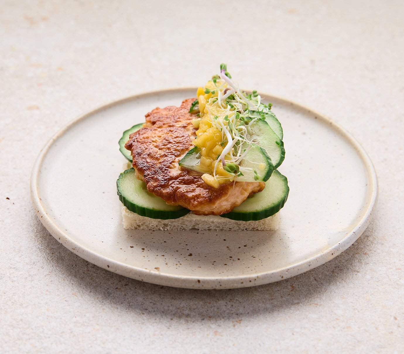 Open salmon patty sandwich with mango sauce