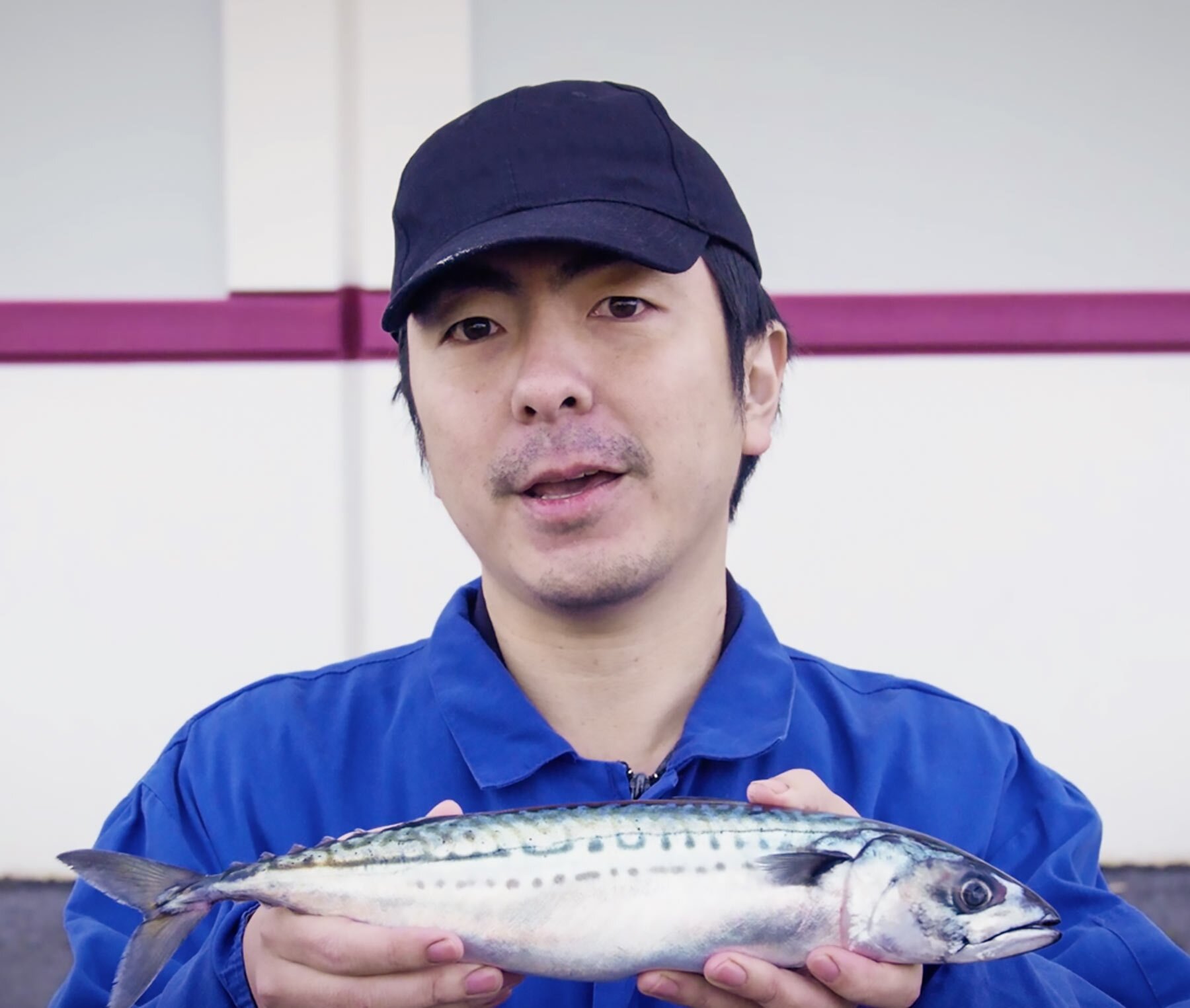 Ken Abe holding up a Norwegian mackerel