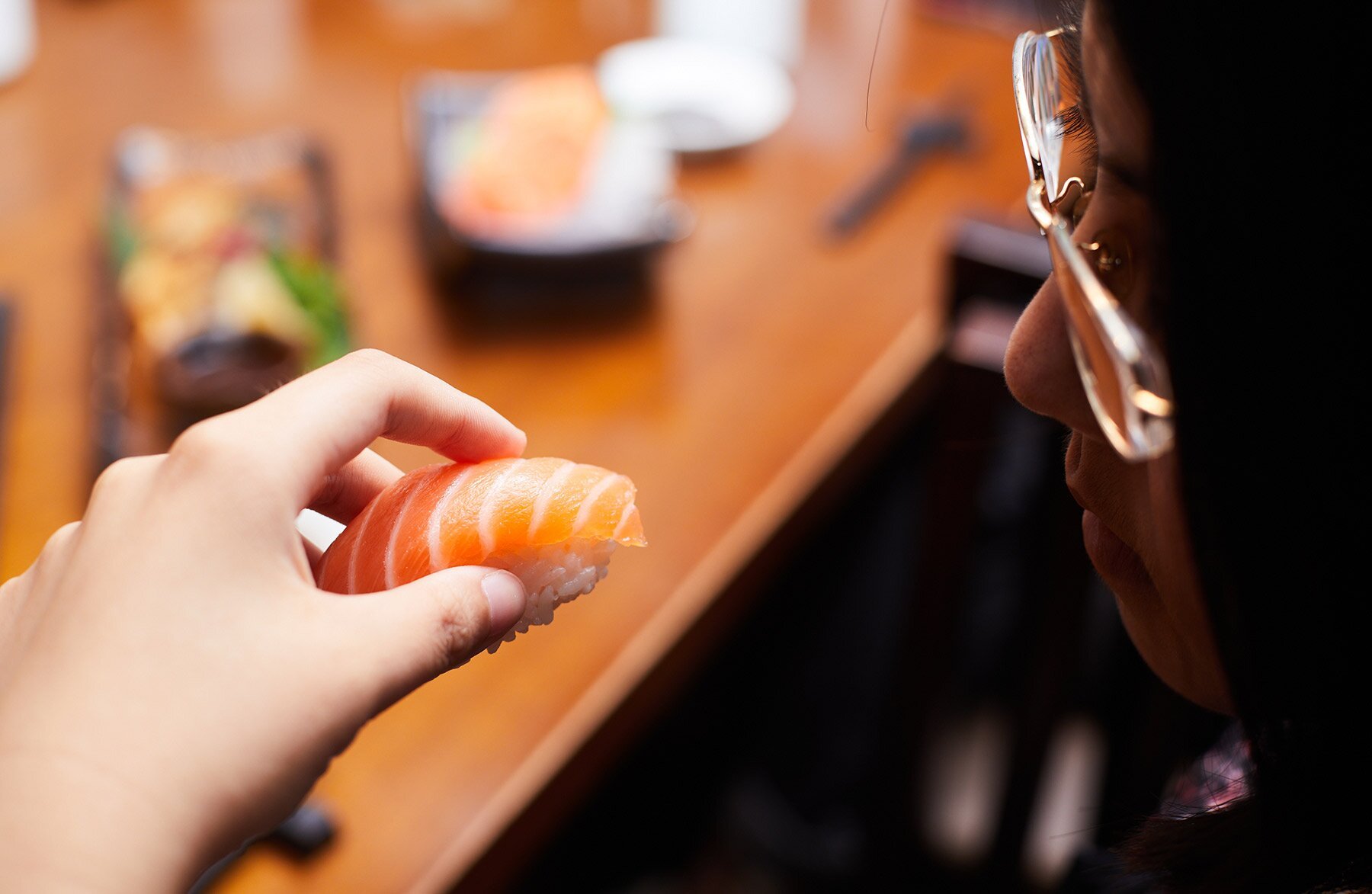 Person eating salmon nigiri